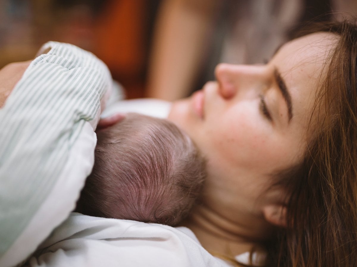 En kvinna med ett spädbarn i famnen.