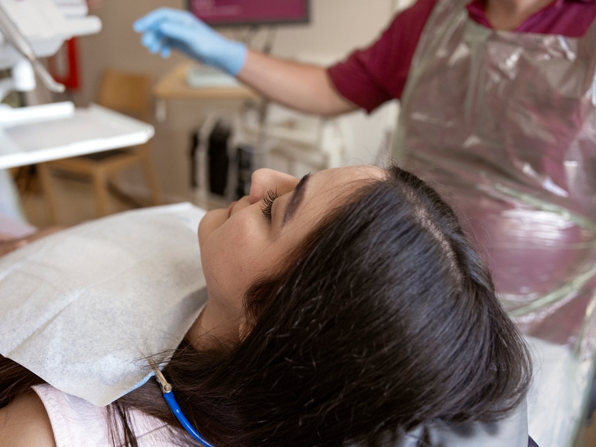 En person som ligger i en tandläkarstol.