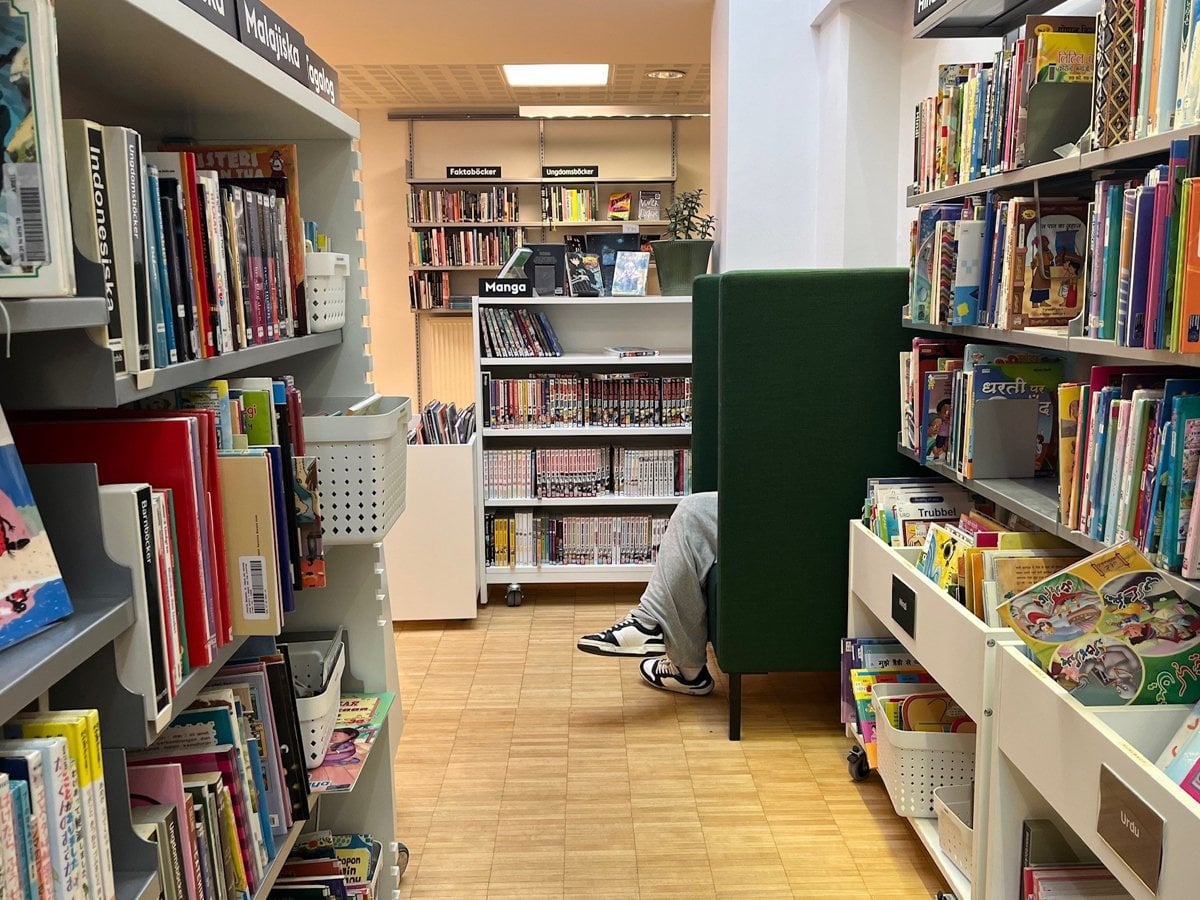 Bokhyllor. Ett fåtölj med höga sidor så man ser vara benen som sticker fram.