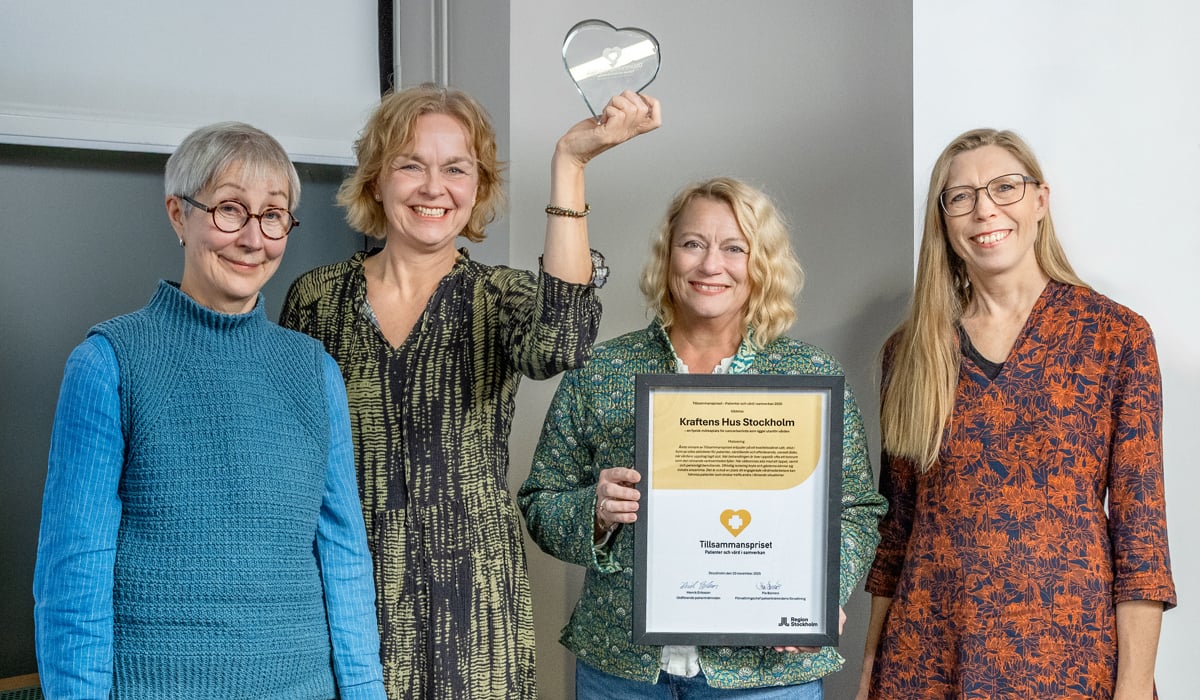 En grupp kvinnor som står bredvid varandra och håller i en plakett.