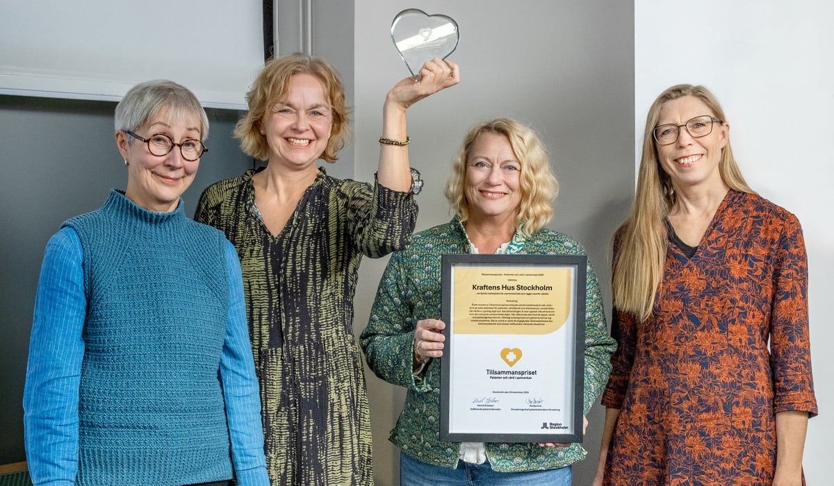 En grupp kvinnor som står bredvid varandra och håller i en plakett.