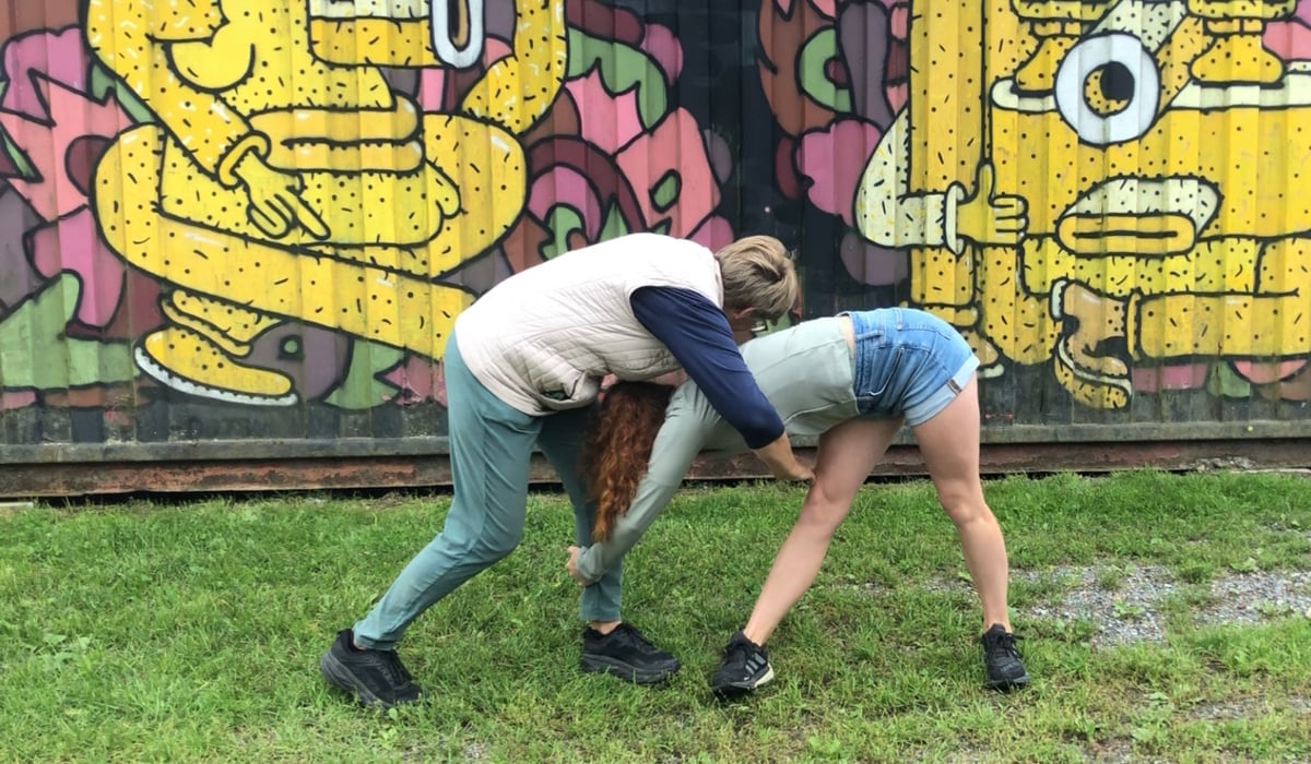 Två unga som dansar framför graffitti-målning.