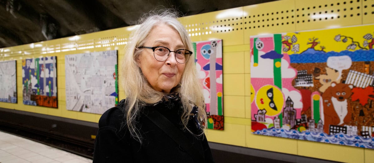 Kristina som står framför en vägg med bilder på.