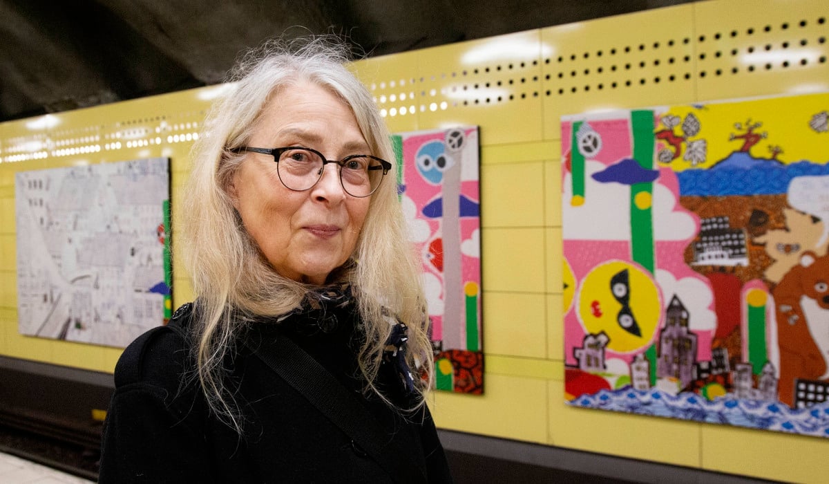 Kristina som står framför en vägg med bilder på.