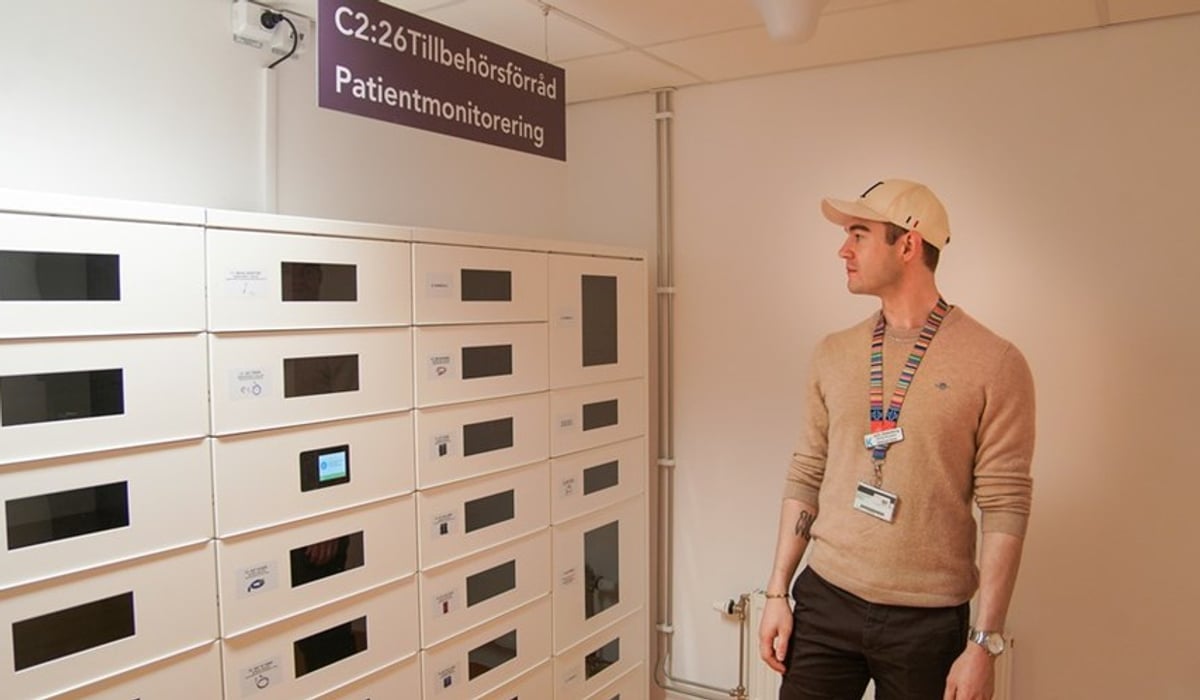 En man står och tittar på ett skåp som innehåller tillbehör för patientövervakning