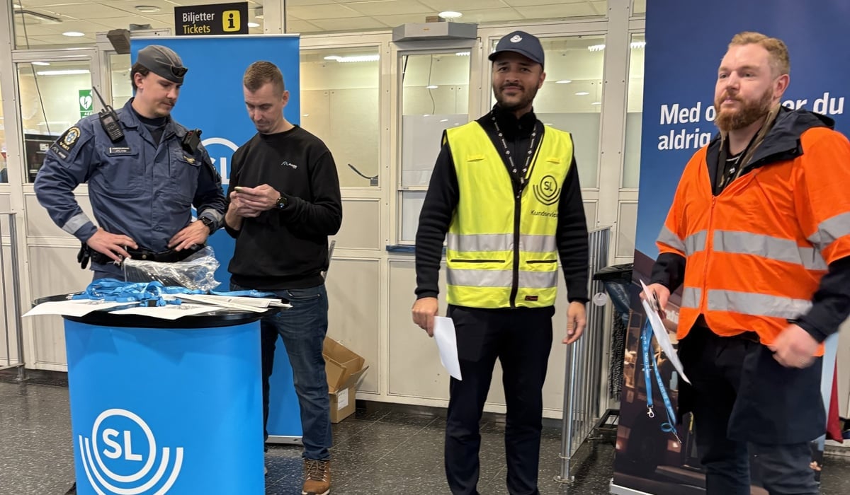 Fyra personer står framför en monter som det står SL.