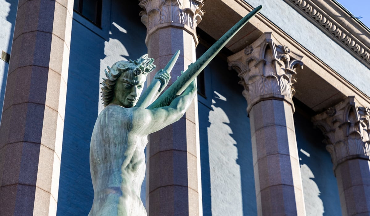 En staty av en man som håller ett svärd framför Konserthuset.