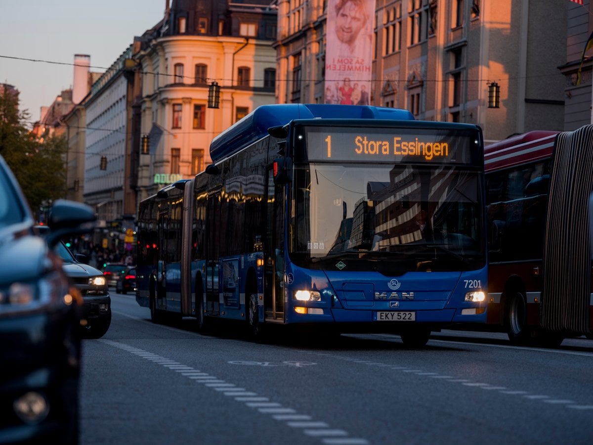 Solnedgång i centrala Stockholm reflekterar sig mot den blåa bussen
