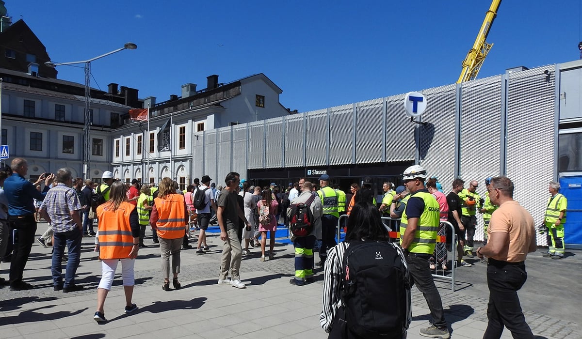 En grupp människor som står framför en stationsingång.