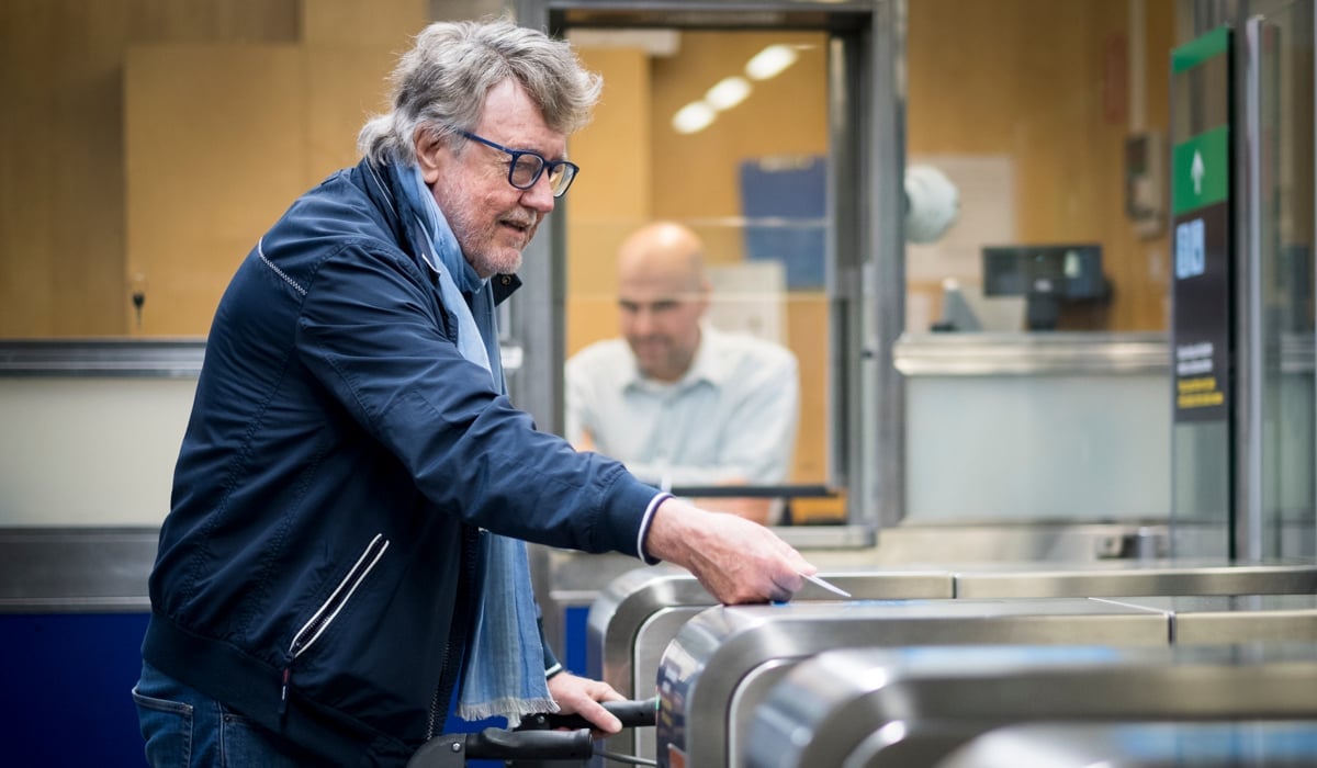 Äldre man med rullator reser med tunnelbanan