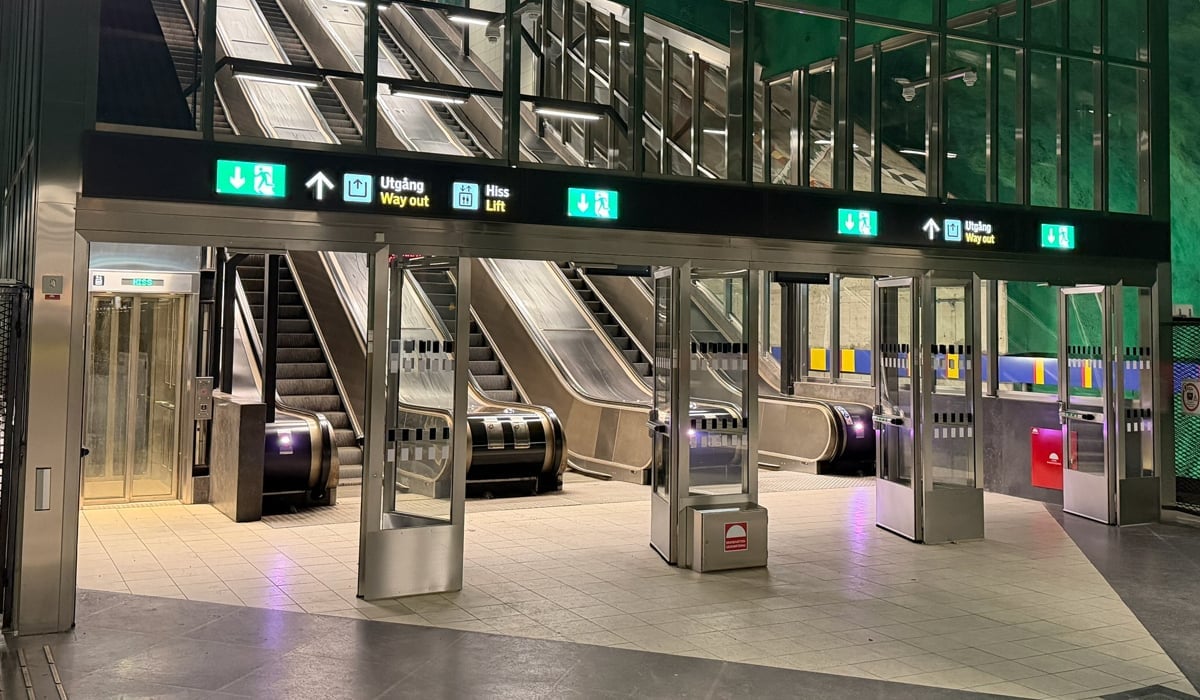 En tom tunnelbanestation med trappor och en grön vägg.