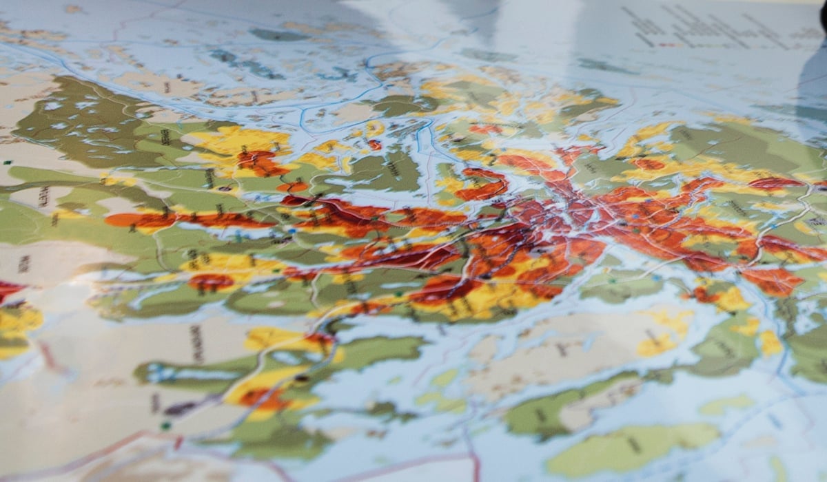 Kvinna kollar på karta över Stockholms län