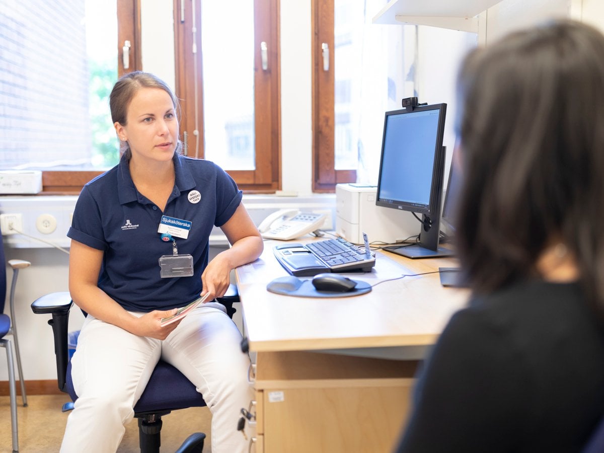 En kvinna sitter vid ett skrivbord med en dator.