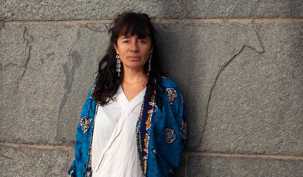 Trinidad står mot en stenmur.