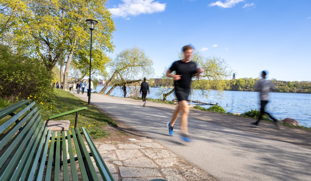 Personer promenerar eller löper längs vattnet.
