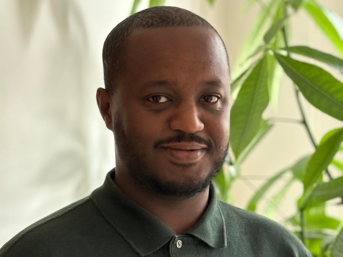 Johannes porträttbild. En grön växt anas i bakgrunden.