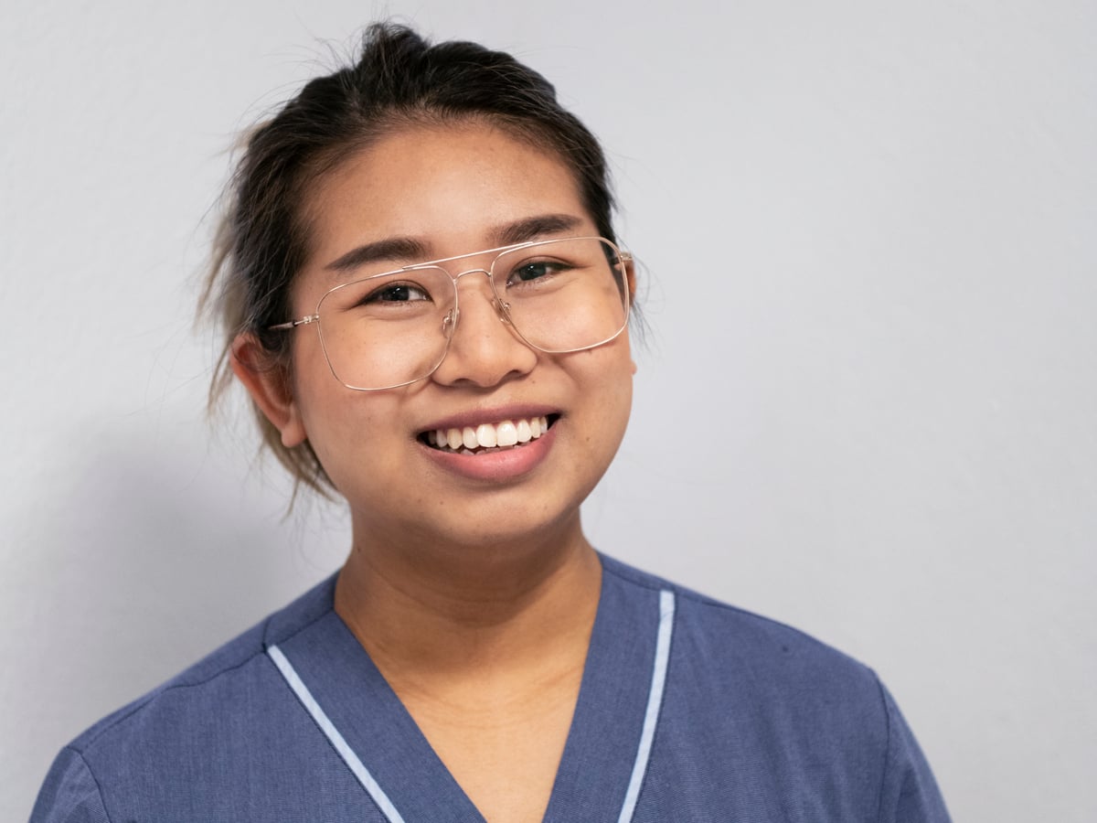 En kvinna i vårdkläder håller i en skrivplatta.