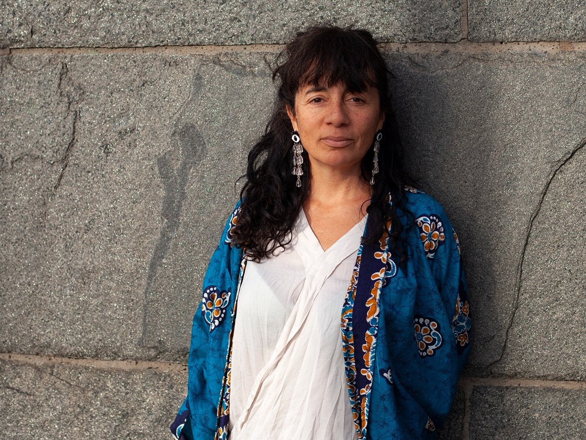 Trinidad står mot en stenmur.