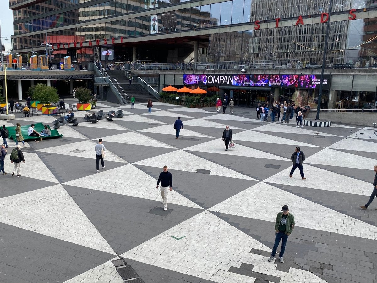 Människor som går i olika riktningar på Sergels torg i Stockholm.