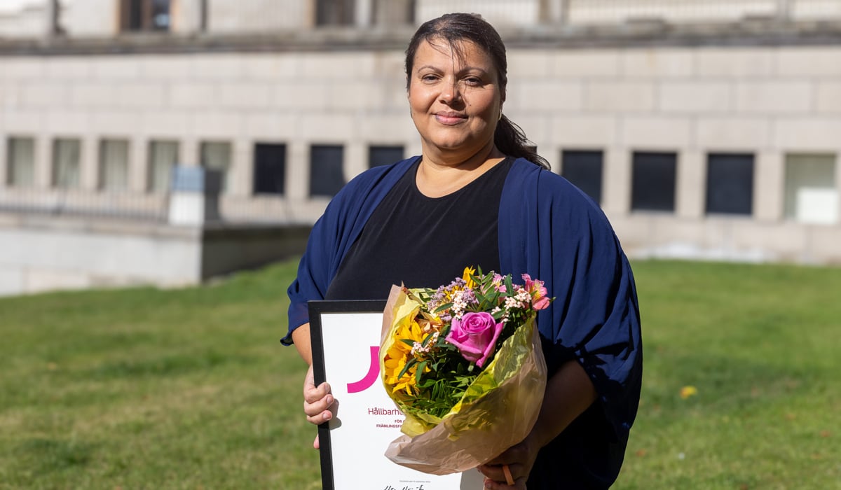 Foto på Sevgi Zengin som håller i blommor och diplom