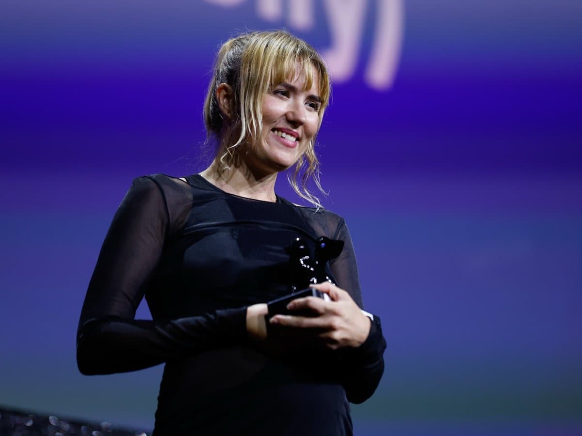 Glad kvinna som håller i en svart prisstatyett.