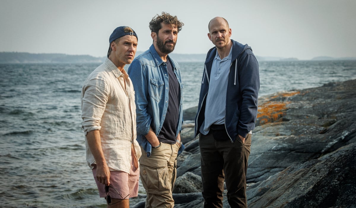 Tre allvarliga män i på en karg skärgårdsö