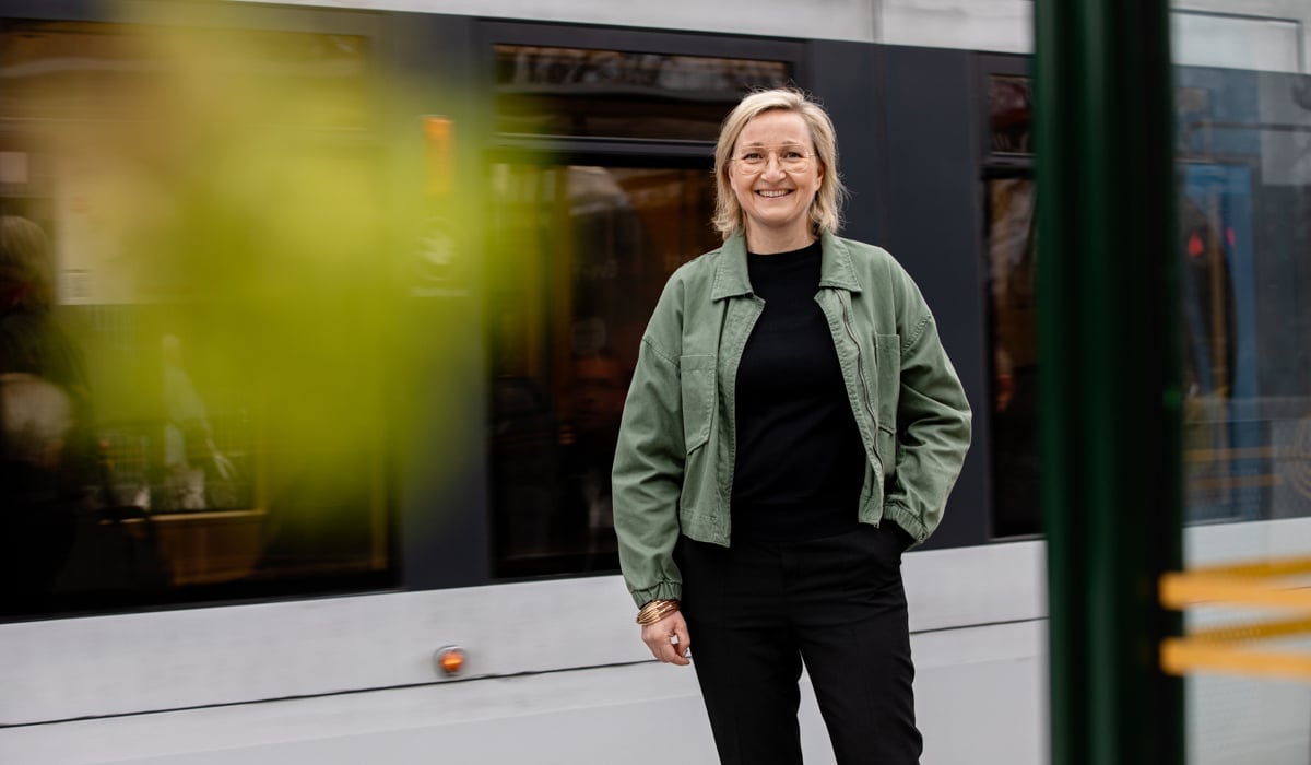 En kvinna som står framför ett tåg.