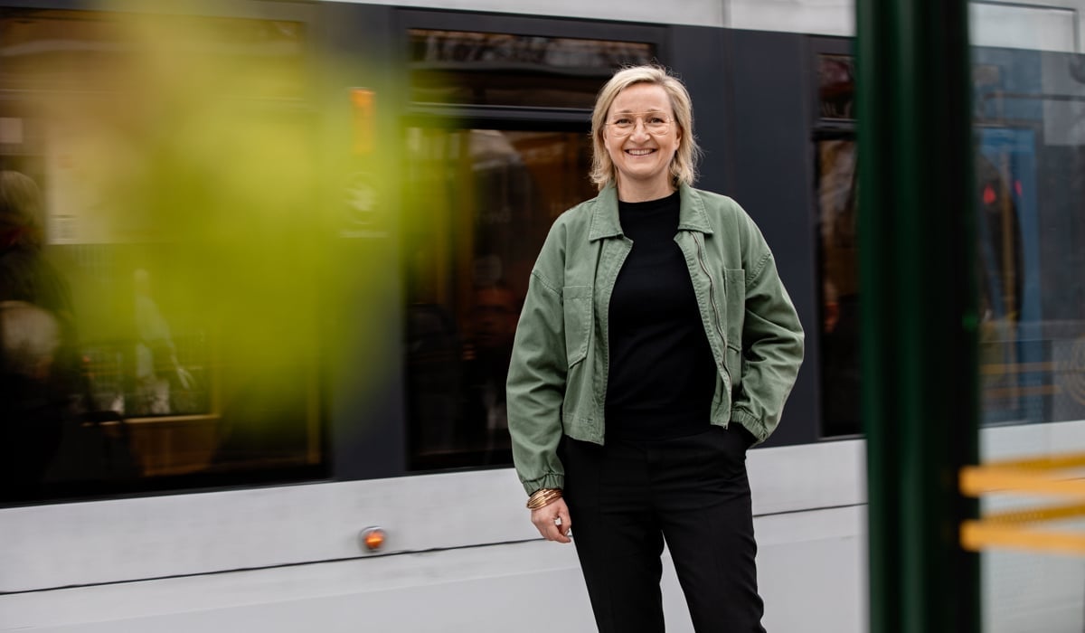 En kvinna som står framför ett tåg.