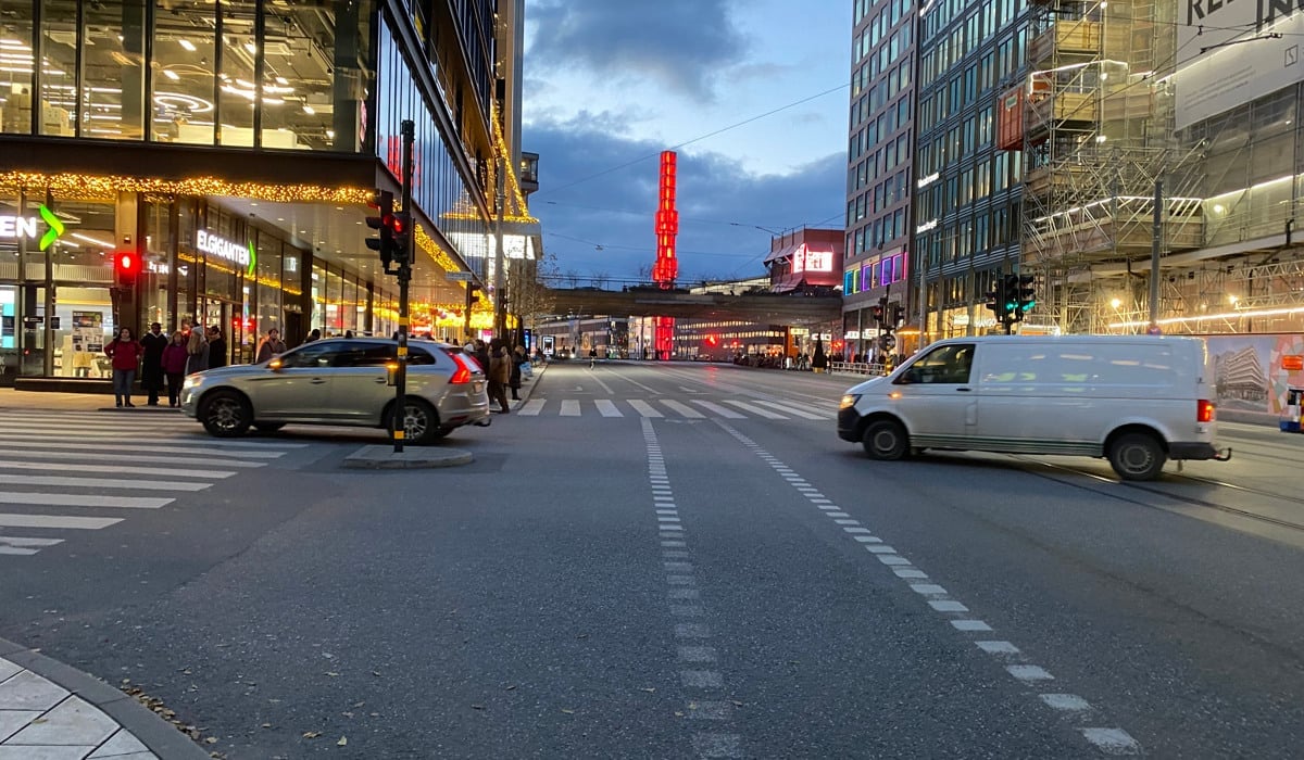 Två bilar svänger av från Hamngatan i kvällsljus