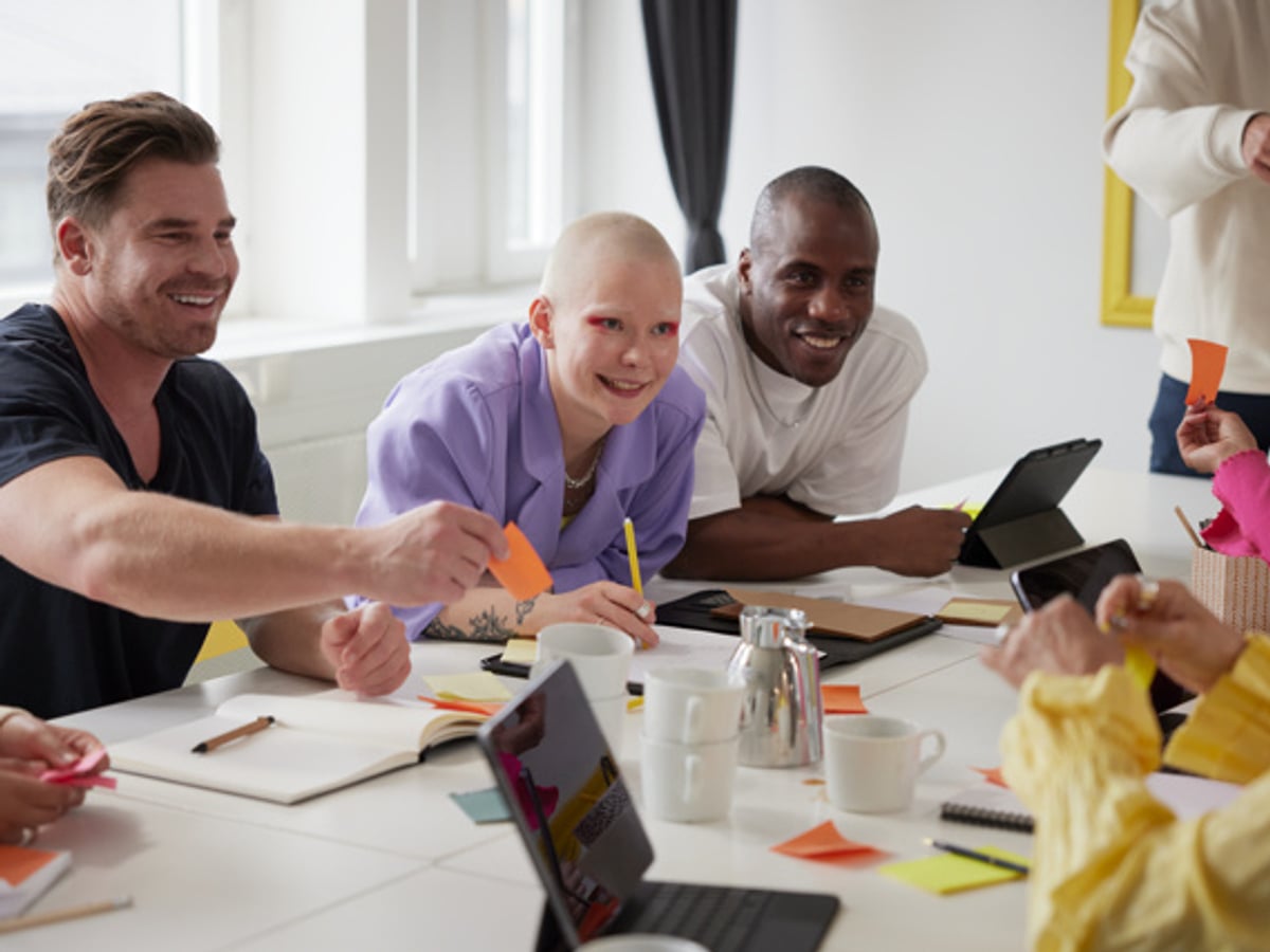 Grupp personer som har ett möte och arbetar med en uppgift.