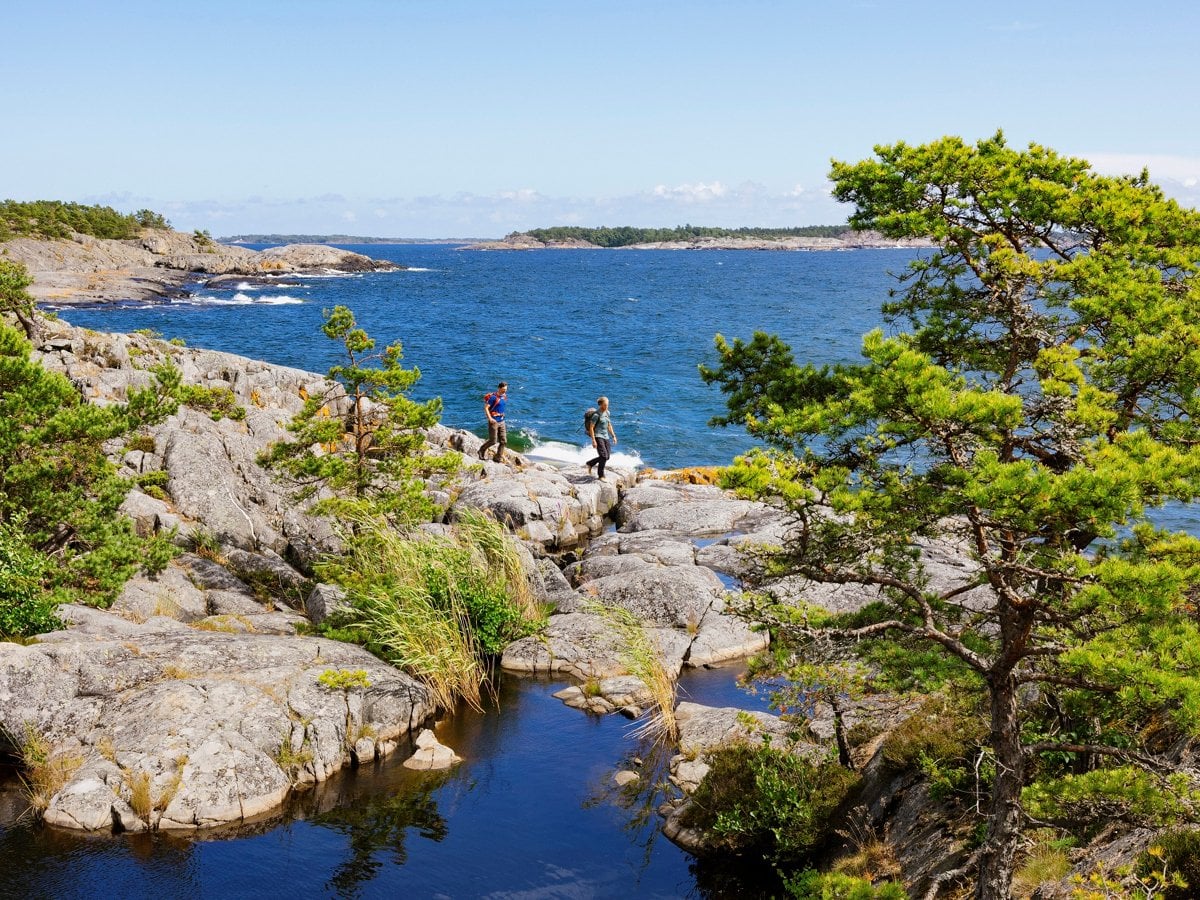 Två personer går på en vandringsled i skärgården