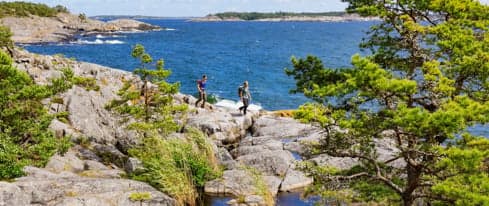 Två personer går på en vandringsled i skärgården