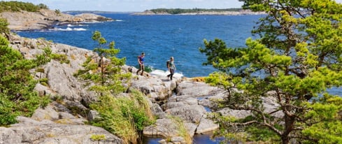 Två personer går på en vandringsled i skärgården