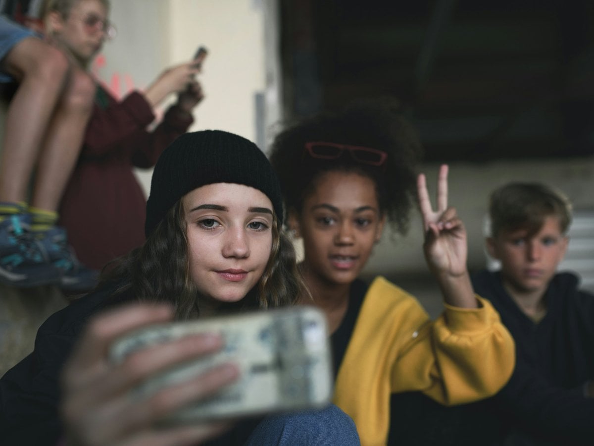 En grupp ungdomar tar en selfie med mobilen