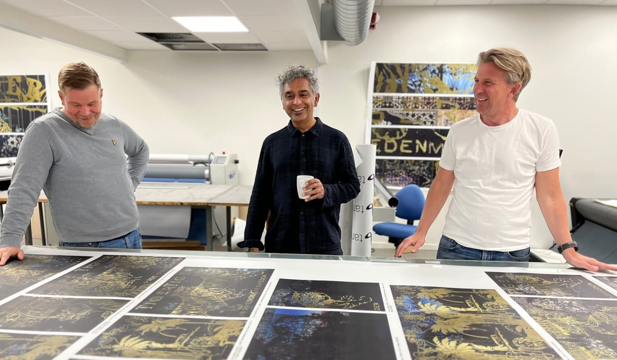 En grupp män som står runt ett bord med bilder på.