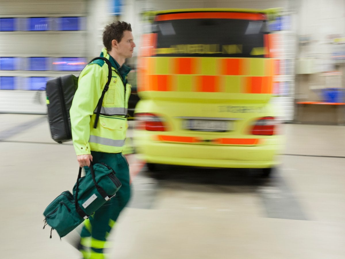 En man med en ryggsäck och en ryggsäck går i ett parkeringsgarage.