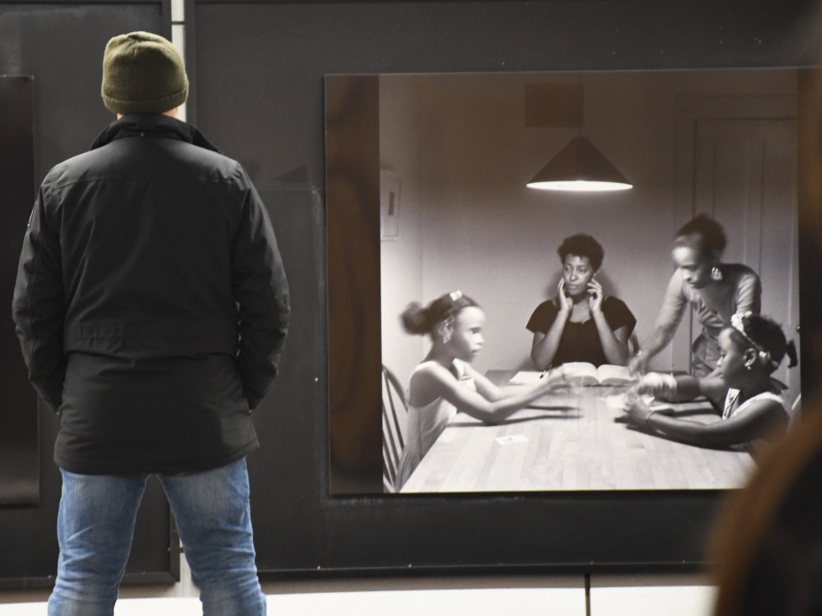 En man står framför två bilder av kvinnor.