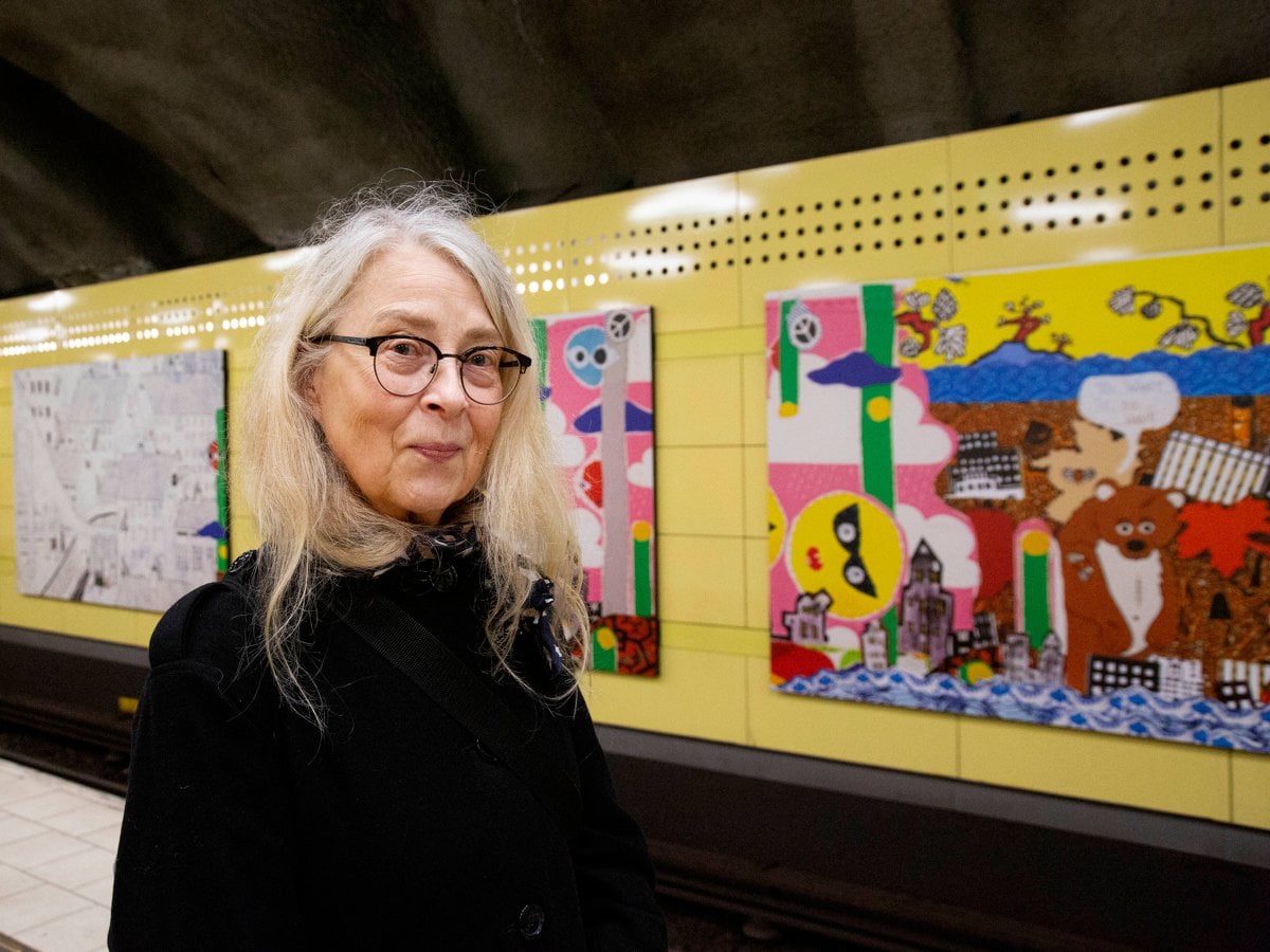 Kristina som står framför en vägg med bilder på.