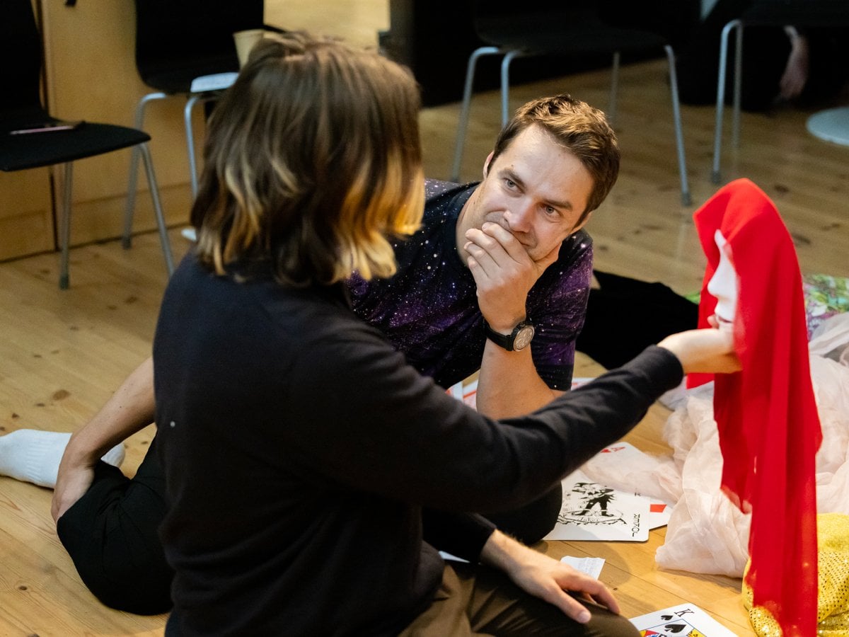 En man sitter på golvet bredvid en kvinna.