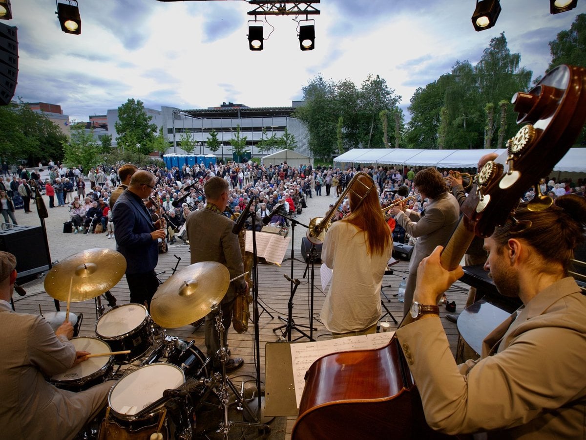Foto på band på scen på jazzfestivalen. Fotot är taget bakom bandet med vy ut mot publiken.