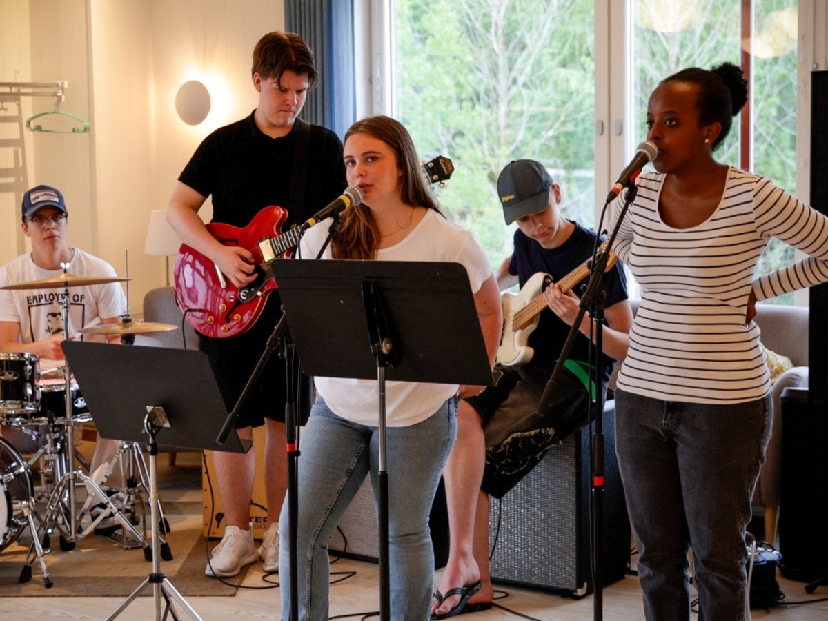 Fem ungdomar spelar och sjunger tillsammans i ett band.
