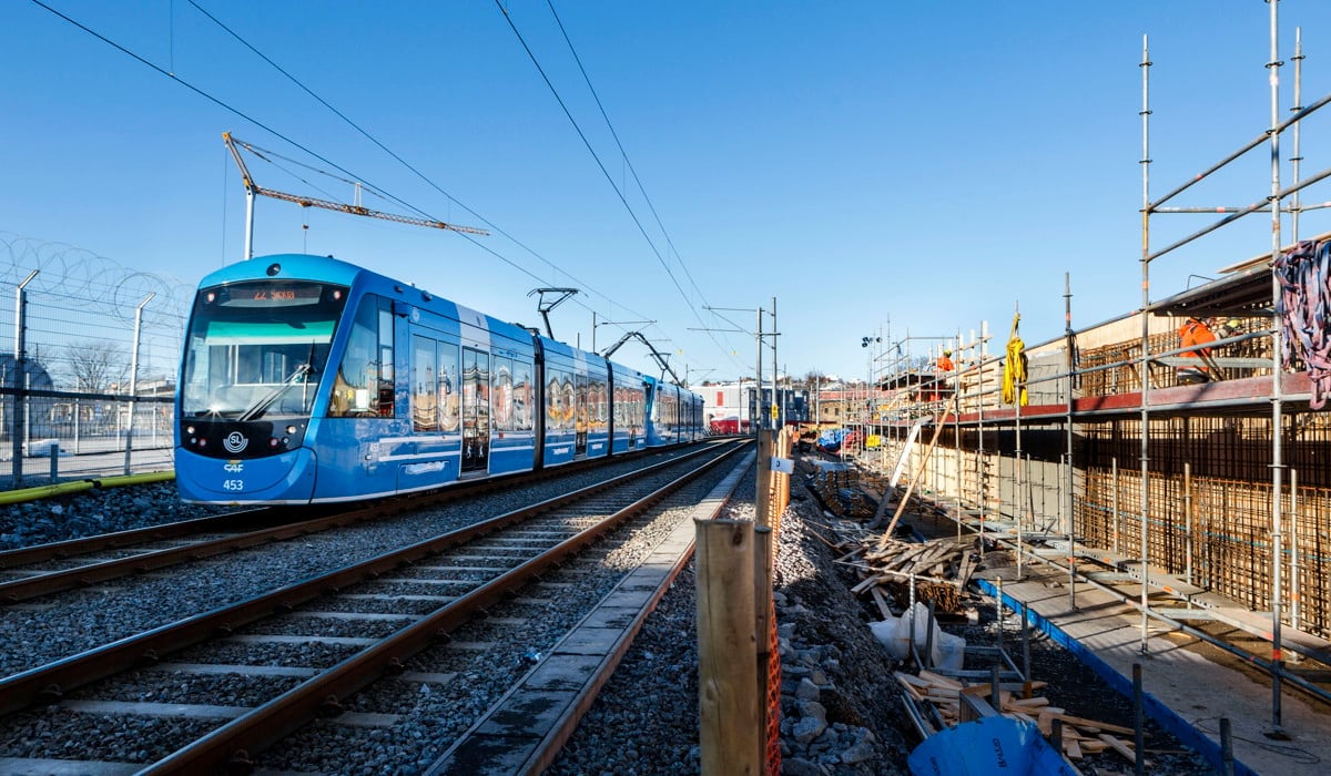 En blå spårvagn kommer åkandes på befintlig tvärbana.
