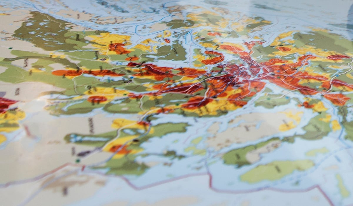 Kvinna kollar på karta över Stockholms län