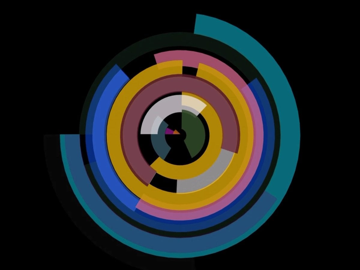 Filmruta från videoverk av KAtarina Löfström. Svart botten med roterande färger i cirkeldiagram.