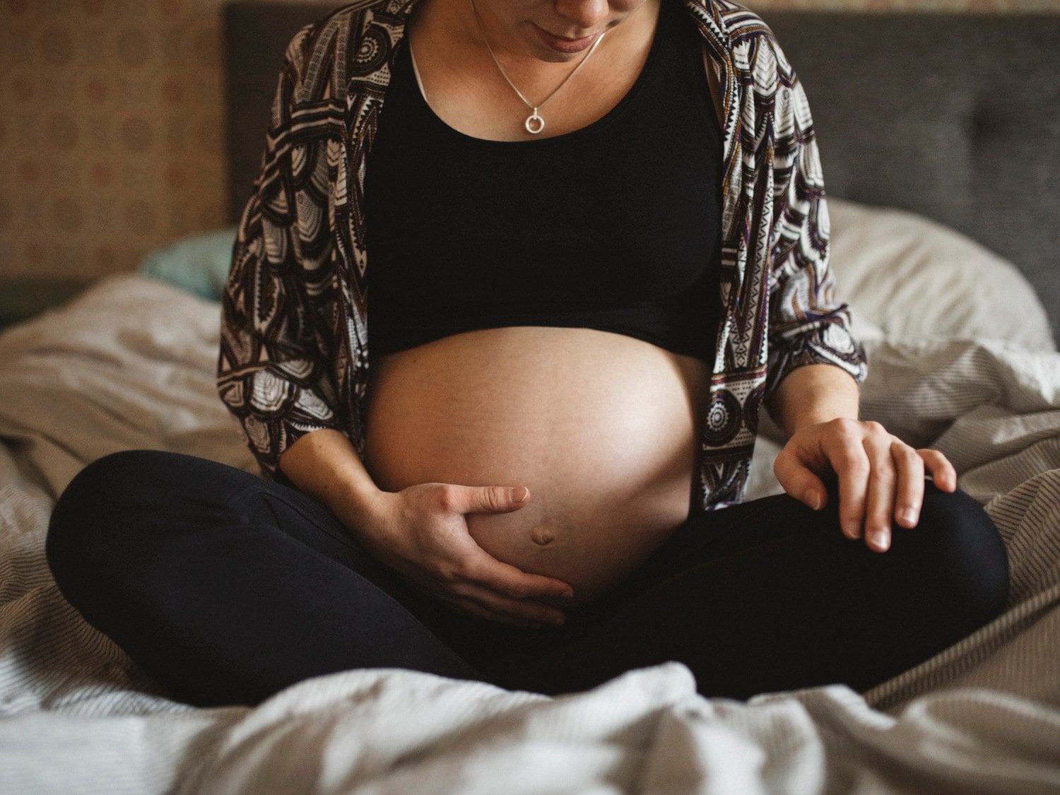 Gravid kvinna som håller handen på sin mage