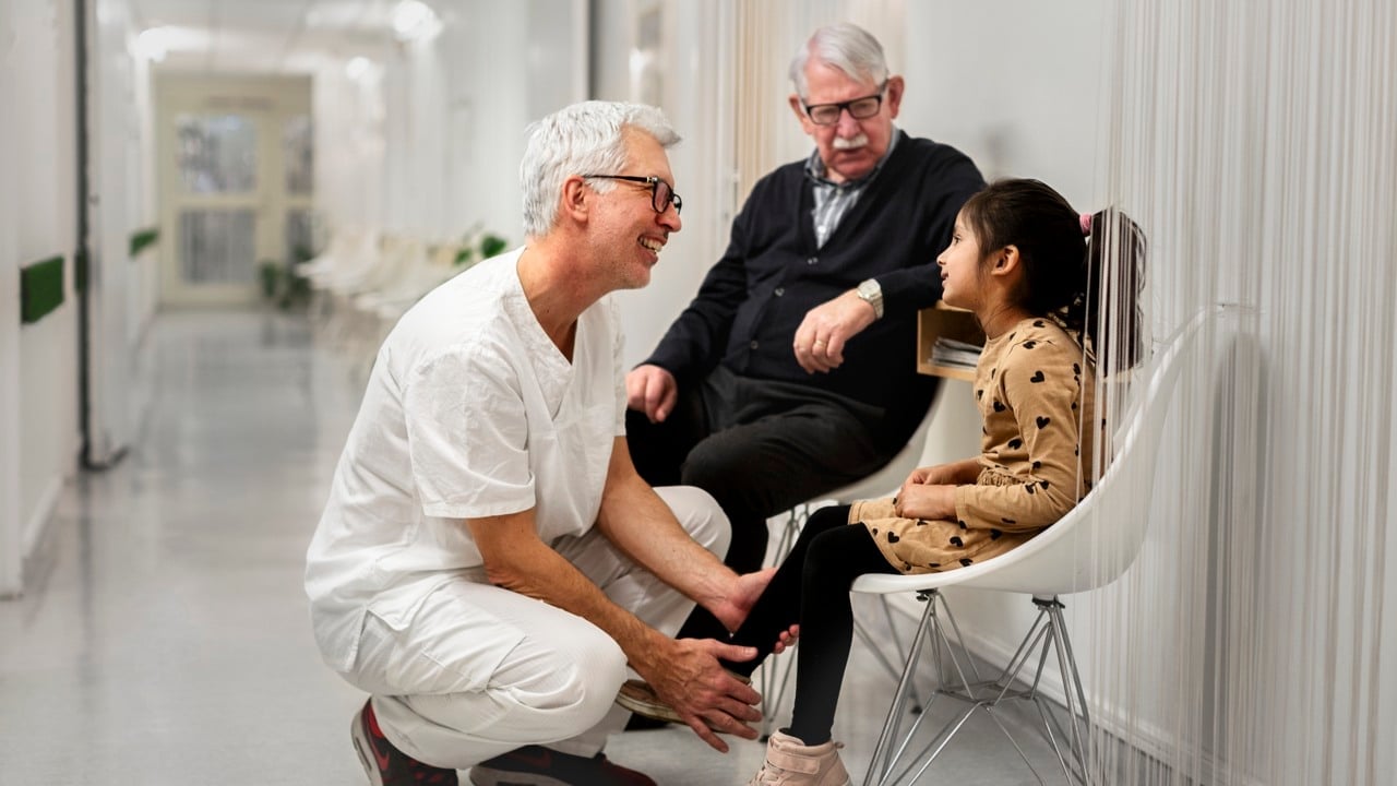 En medarbetare inom vården undersöker en liten flickas ben