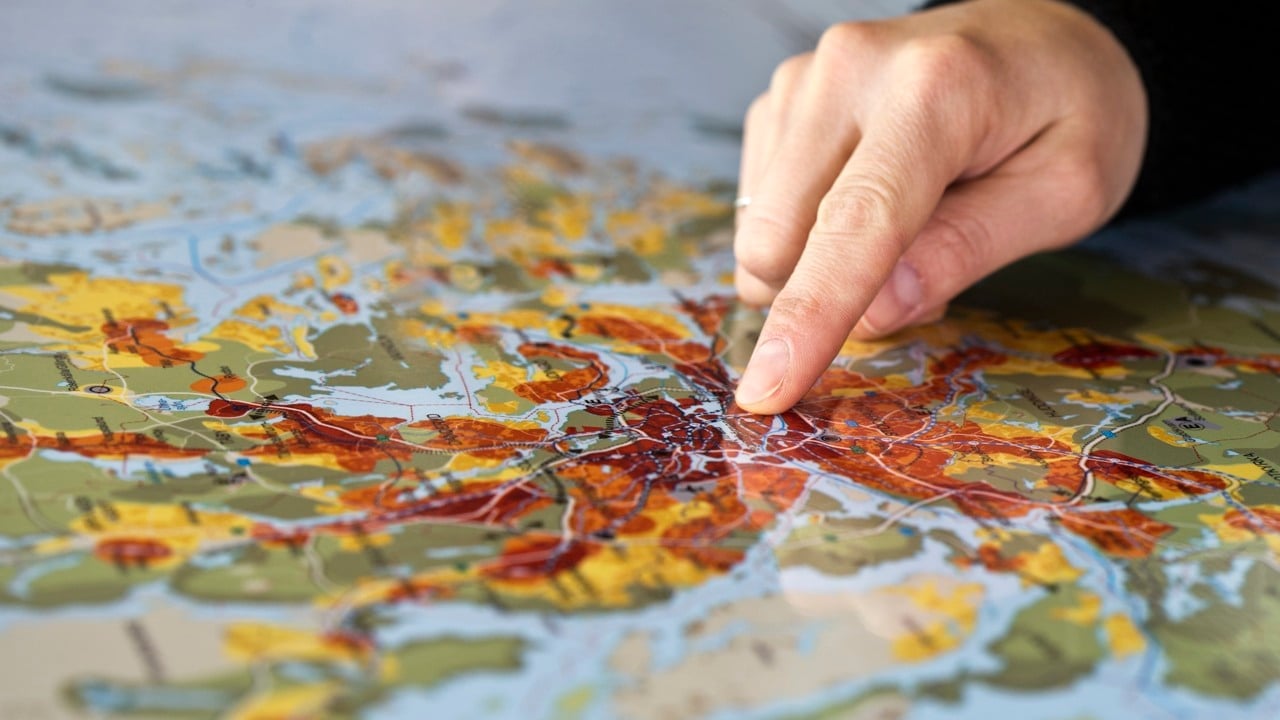 En hand pekar på en karta över Stockholm