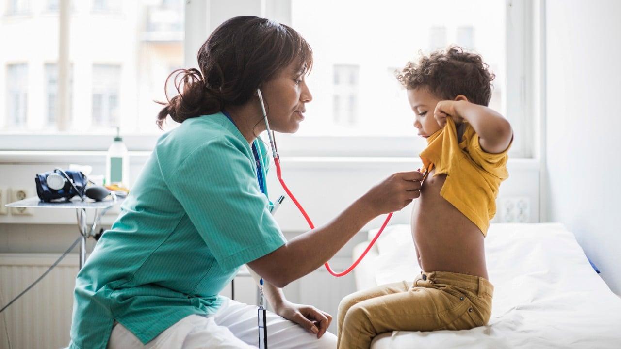 Ett barn blir undersökt av en läkare med stetoskop