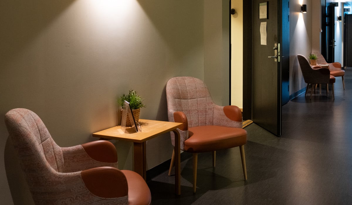 Två stolar och ett bord i ett väntrum.