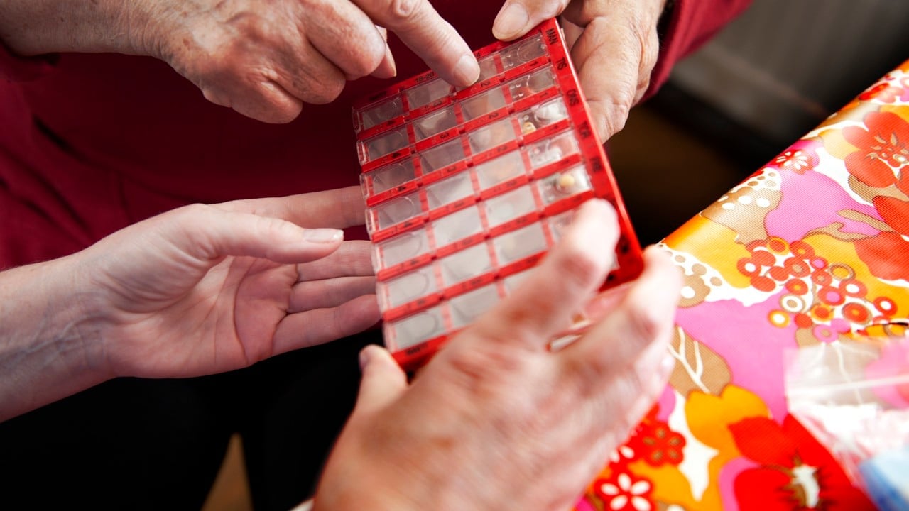Två personer håller i en läkemedelsdosering